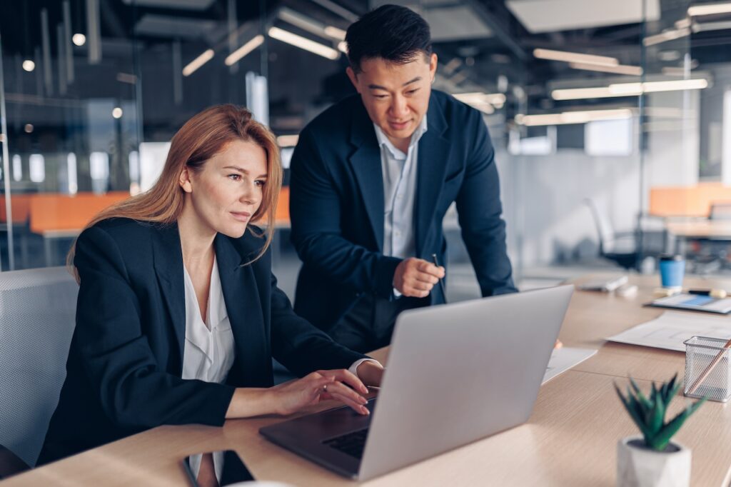 two coworkers working on computer in office