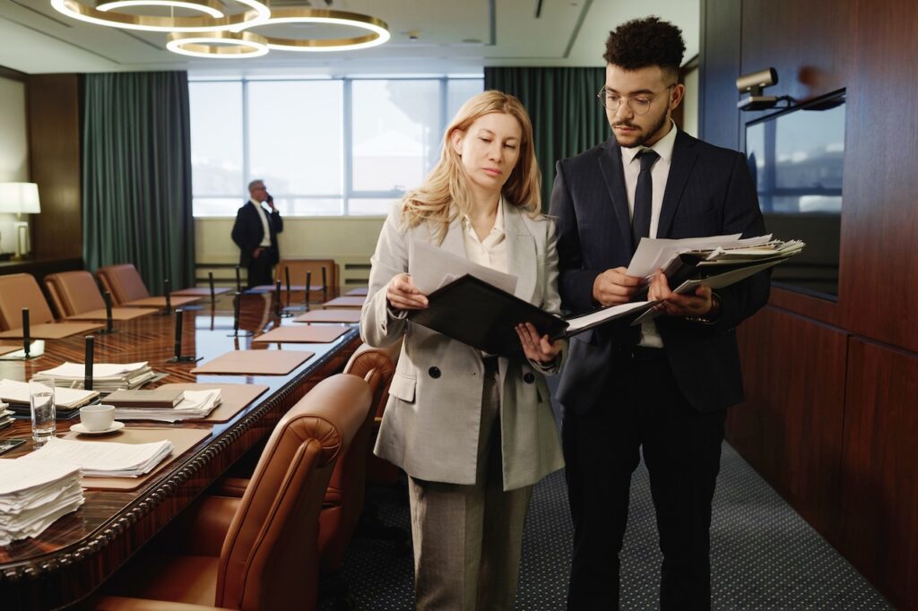 attorneys in board room looking over case files for law firm