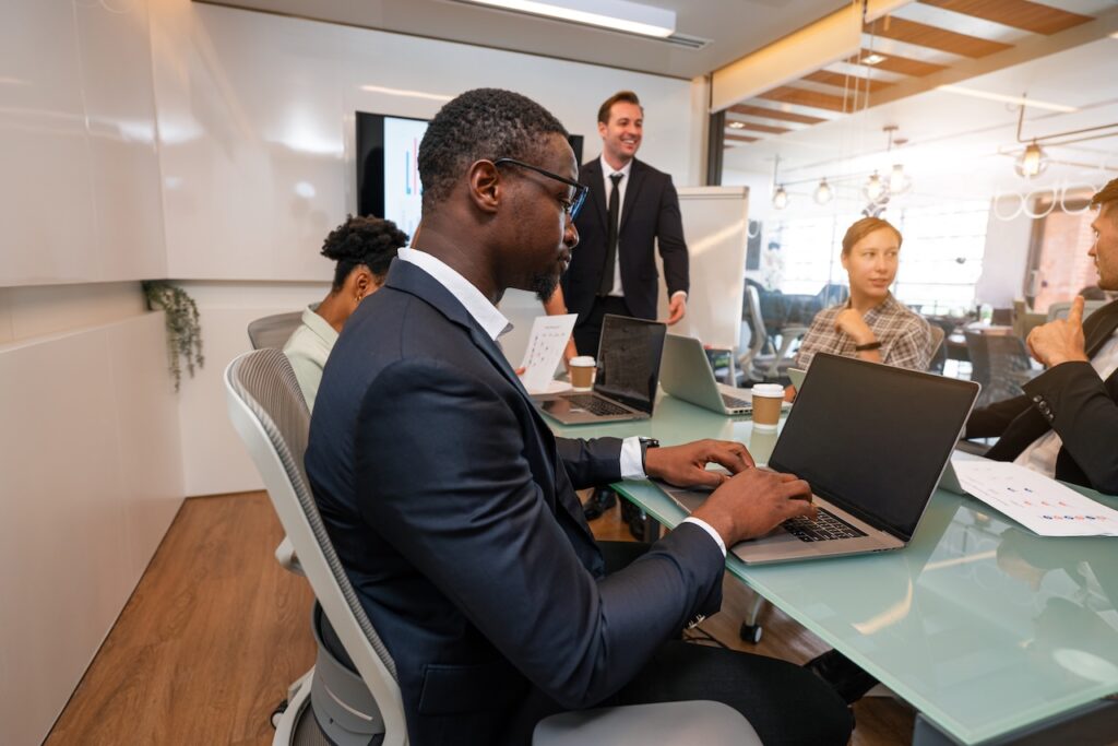 coworkers in a conference room meeting using managed security to keep their computers secure