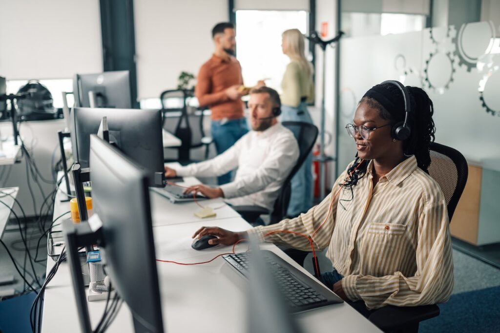 Customer service agents working on computers in office with network security solutions