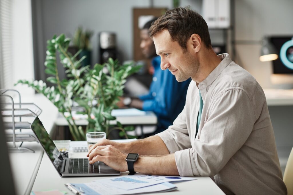 man working on laptop in office using it support services